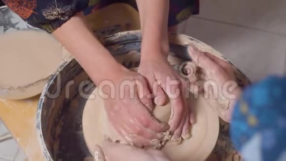 女性的手在旋转的陶工车轮上视频的预览图