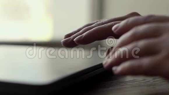 女人的手缓慢地打开靠近窗户的笔记本电脑的盖子视频的预览图