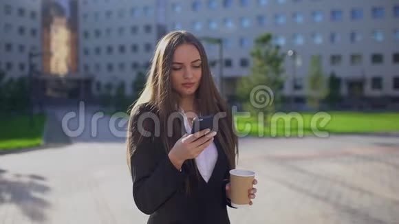 年轻的职业白种人女商人或女学生走路和使用手机智能手机发短信的妇女视频的预览图