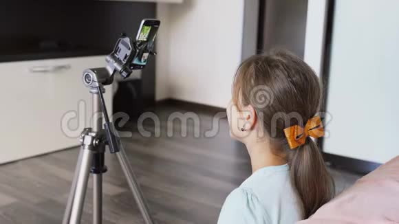 一位年轻的女孩博主正在通过电话在线广播一个年轻女孩正在智能手机上在线广播视频的预览图