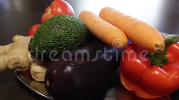 有新鲜蔬菜的大盘子生姜胡萝卜西红柿茄子鳄梨胡椒黄瓜特写镜头a视频的预览图