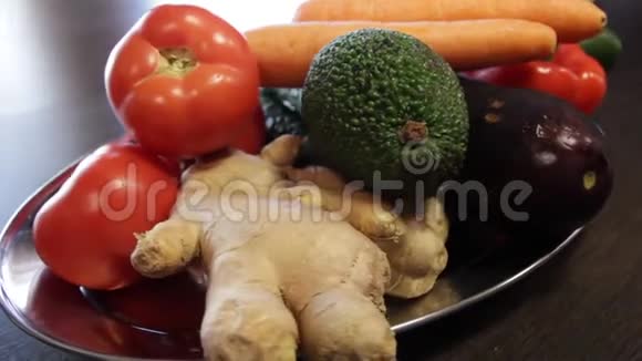有新鲜蔬菜的大盘子生姜胡萝卜西红柿茄子鳄梨胡椒黄瓜特写镜头a视频的预览图