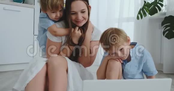爱的母亲和孩子拥抱玩得开心坐在地板上欢乐幸福的家庭接下来的比赛视频的预览图