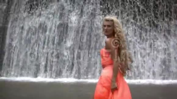 穿着橙色衣服走着的年轻美女视频的预览图