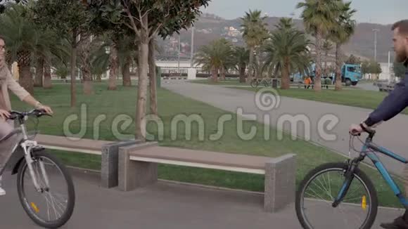 男女朋友在公园里骑自行车散步聊天视频的预览图