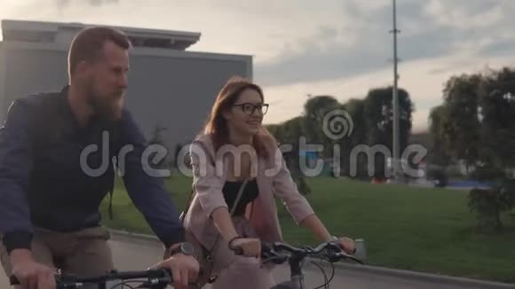 夏天晚上年轻人和他的女朋友在一个城市骑自行车视频的预览图