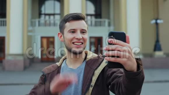 迷人的男性游客在智能手机上有视频聊天视频的预览图