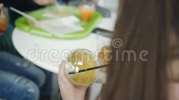 女孩和我爸爸和姐姐在咖啡馆里喝塑料杯里的果汁视频的预览图