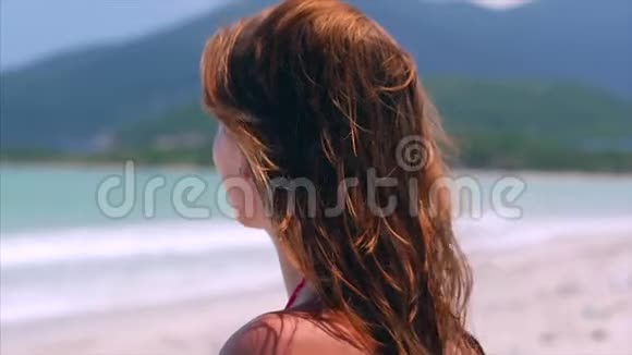 海滩上一位美丽的欧洲妇女的肖像特写眺望远处的大海在大海中放松视频的预览图