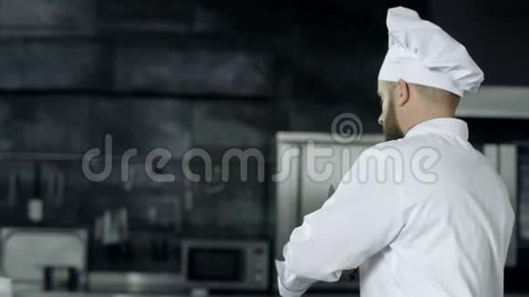 男厨师用交叉刀摆姿势厨师在厨房磨刀视频的预览图