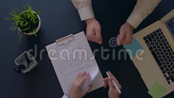 商人乐于签订合同并与坐在桌边的合伙人握手空中射击视频的预览图