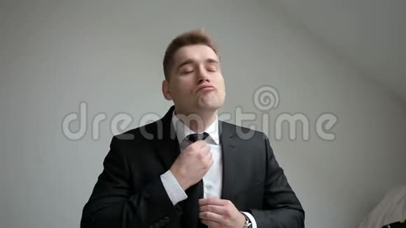 穿着黑色西装调整领带的成功男人视频的预览图