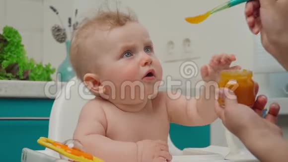 小男孩吃黄色捣碎的食物视频的预览图