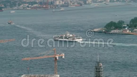 一艘有游客在海湾航行的大船在背景中你可以看到一个大港口与装载起重机视频的预览图