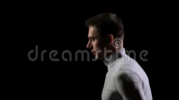 一位英俊的白人男子体操运动员在黑色背景下做杂技特技动作缓慢旋转和翻转感觉有感觉视频的预览图