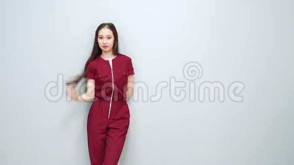 灰色背景下穿制服的年轻微笑的亚洲女人的肖像视频的预览图