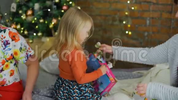 圣诞树旁小女孩解包礼物视频的预览图