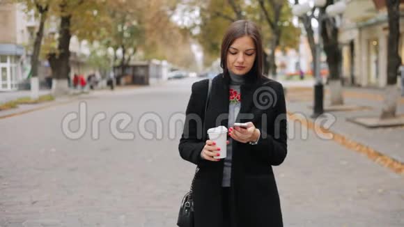女人检查邮件看新闻聊天在街上喝咖啡视频的预览图