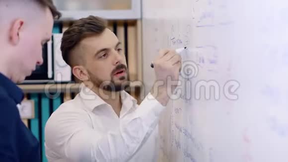 办公室里的男同事正在做这个项目用记号笔在白板上做笔记视频的预览图