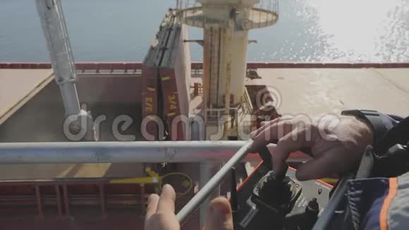 一个人用遥控器控制小麦装载到船上把小麦装进货船视频的预览图