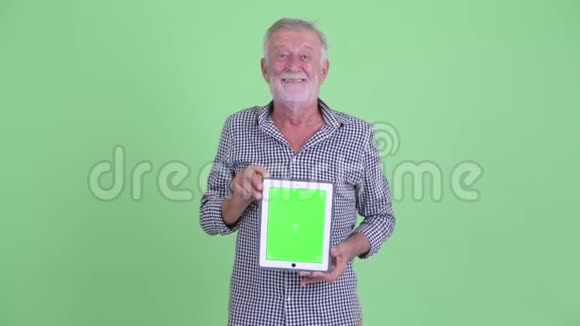 快乐的老胡子先生在看数字平板电脑视频的预览图