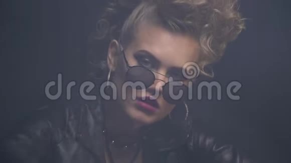 戴墨镜的不尊敬的摇滚女人露出中指闭上眼睛视频的预览图