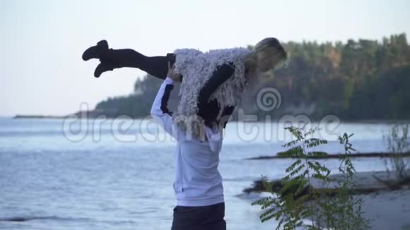 一个亚洲人把他的白种人女朋友抱在他的头上背景是湖泊和森林穿休闲装的青少年视频的预览图