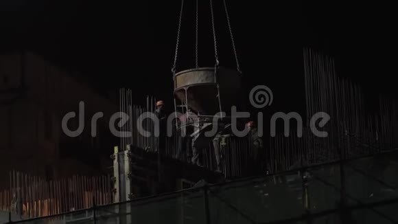 夜间施工施工人员通道搅拌机悬挂在起重机上视频的预览图