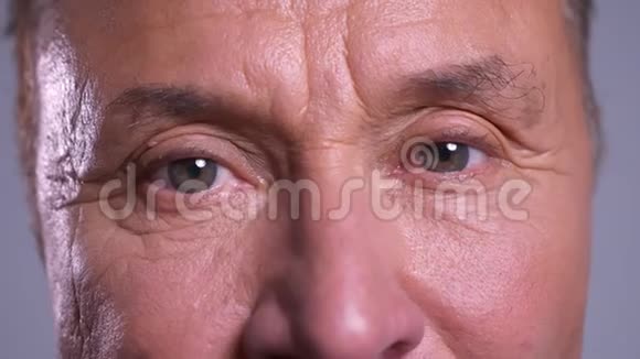 特写皱纹的白种人男性灰色眼睛直视镜头面部表情中性视频的预览图