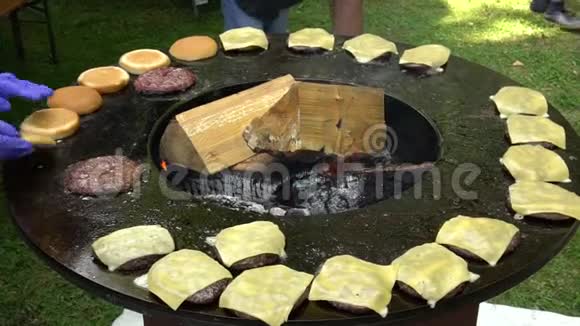 汉堡肉奶酪和面包用木柴烤在户外烤架上手持射击视频的预览图