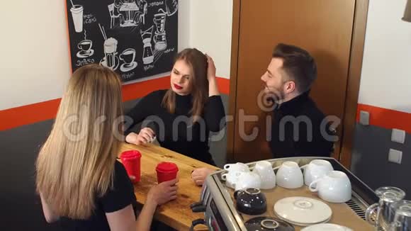 一个微笑的女酒保给坐在咖啡馆柜台旁的一对夫妇喝酒视频的预览图