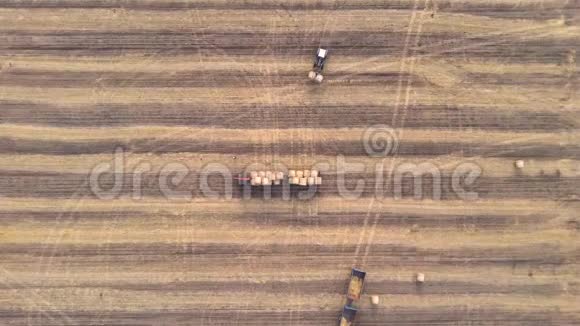 农场拖拉机在农田上装载干草堆装载稻草卷视频的预览图