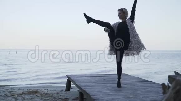 灵活的女孩在水面背景上的木制平台上跳舞年轻的白种人美女视频的预览图