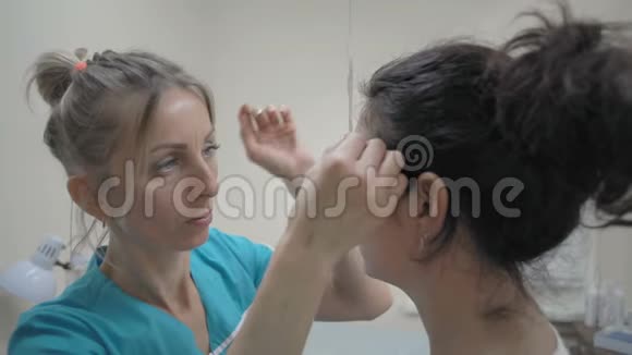 特写美容师用轮廓尺测量女性眉毛视频的预览图