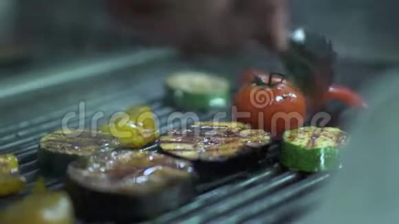 厨师手转向另一边蔬菜番茄茄子西葫芦黄铃椒烤架上使用金属视频的预览图
