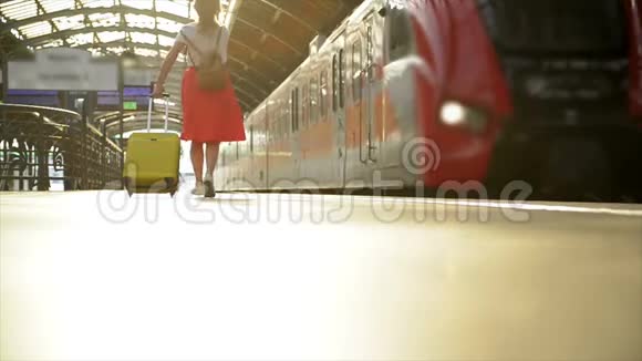 年轻的白种人女人带着西装跑着在火车离开车站之前抓住火车视频的预览图