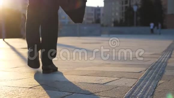 日落时分商人的双脚带着公文包走在城市街道上商人上下班自信的家伙视频的预览图