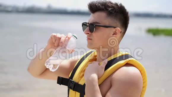 适合男人在海滩边喝瓶子里的水视频的预览图