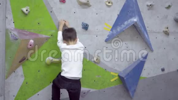 爬岩石墙时摔倒的男孩视频的预览图