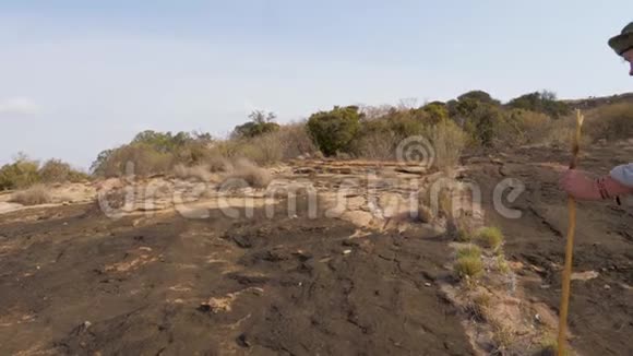 在非洲一片休眠的火山上妇女在冰冻熔岩的石台上徒步旅行视频的预览图