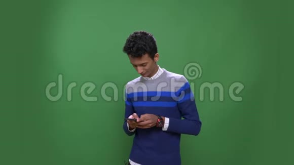 印度年轻有魅力男性的特写镜头手机背景与绿色隔离视频的预览图