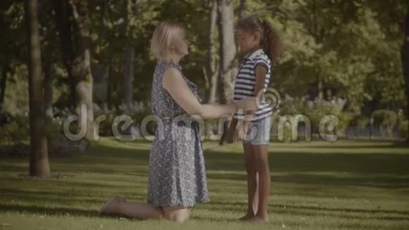 可爱的母亲在公园安慰她伤心的女儿视频的预览图