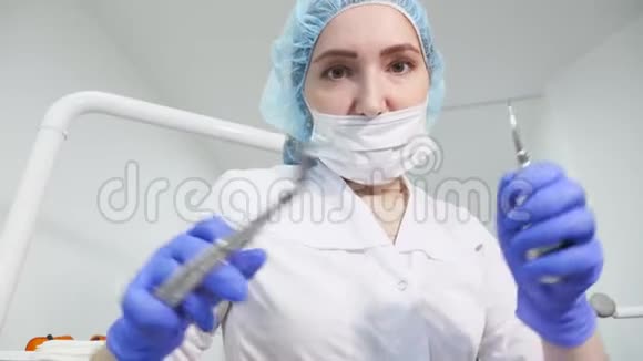 牙科医生手里拿着牙科器械钳和针看着相机视频的预览图