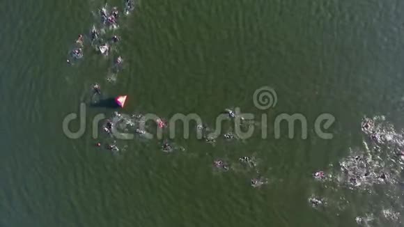 浮在水面上的铁人三项赛旁路浮标上的高空游泳者视频的预览图