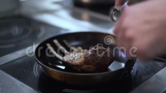 厨师的双手用酒精倒入新鲜美味的排骨点燃它准备开胃菜视频的预览图