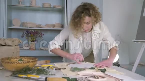 手工艺品年轻的陶工女性在餐桌上用灵感制作陶器视频的预览图