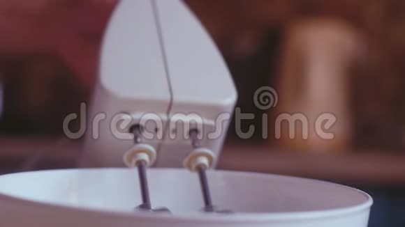 甜点从一碗奶油搅拌机中抽出里面有旋转的金属刀片视频的预览图