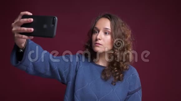 特写照片上年轻迷人的白种人女性在电话中自拍修头发在前面微笑视频的预览图