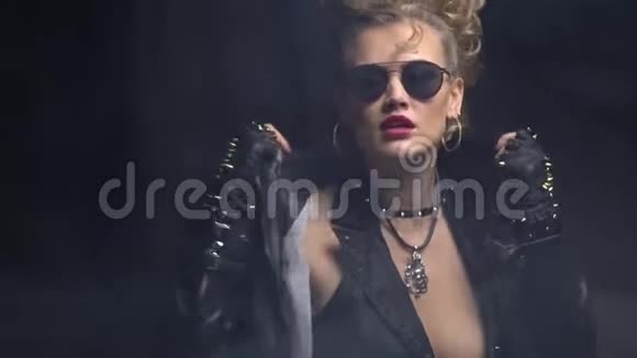 穿着黑色衣服的年轻摇滚女孩在夹克上调整衣领视频的预览图