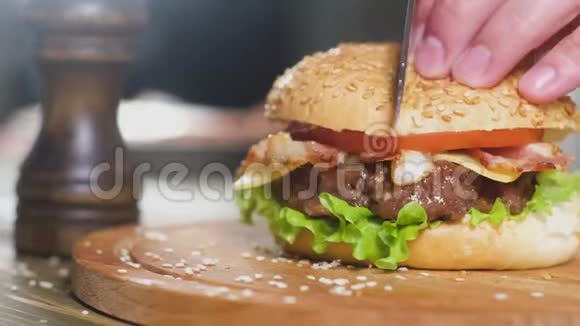 厨师刀在厨房背景上的木制圆形托盘上切割汉堡视频的预览图